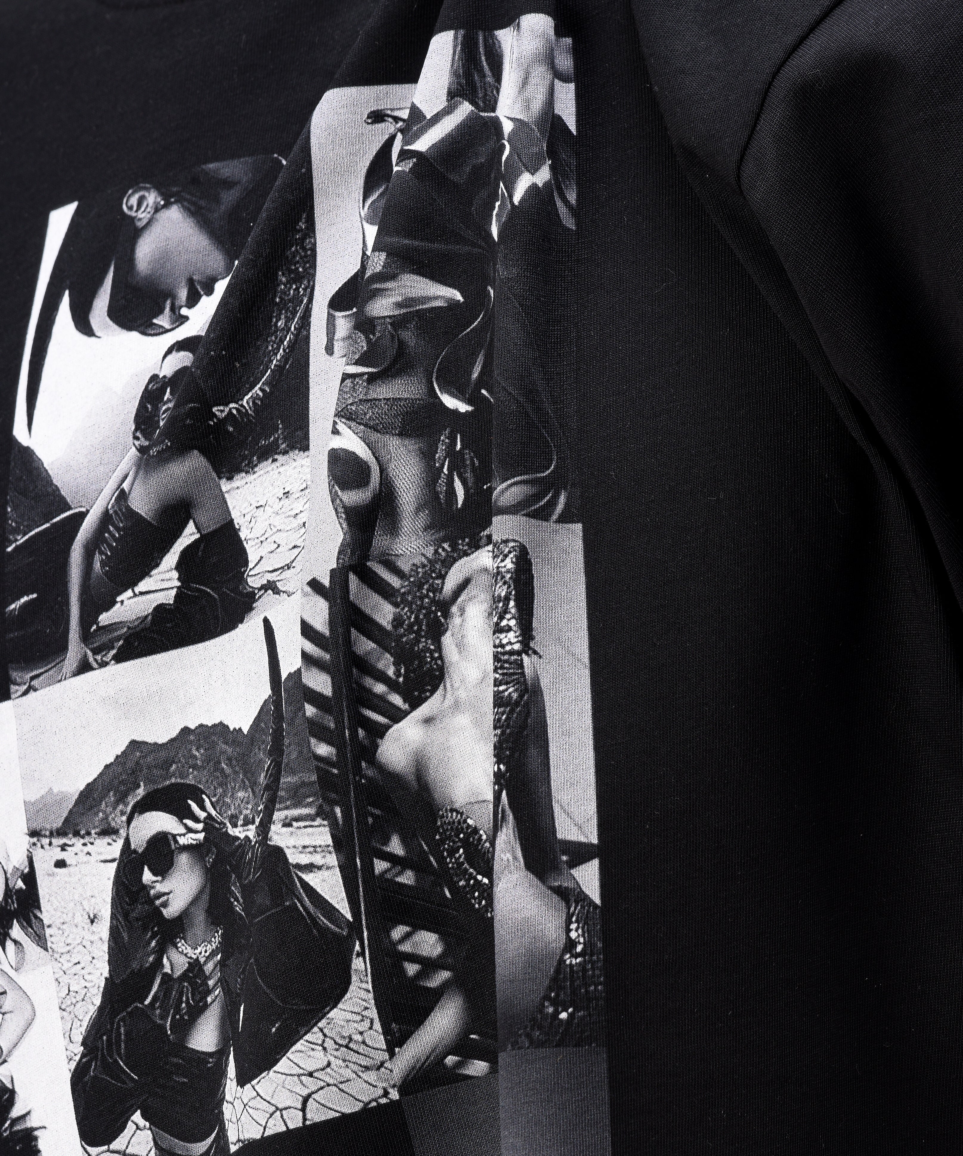 A black t-shirt, viewed from the front, with a big print of a photo montage and elements of the brand Valeryia Lubchonak, close-up.